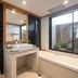 Comsaed River Kwai Resort in Kanchanaburi bathroom with bathtub, vanity sink and large window