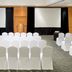 Real Inn Perinorte in Tlalnepantla meeting room set with rows of white-covered chairs and projection screens