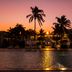 Golden Tulip Dar Es Salaam waterfront sunset view with palm trees and glowing pool reflections