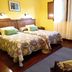 Hotel Casa Vieja del Sastre in Soto de Luiña: twin beds in a bright yellow guest room with large window