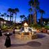 Omni Rancho Las Palmas Resort & Spa in Rancho Mirage, palm-lined courtyard with lit fire fountain at dusk