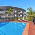 The Wellington Apartment Hotel Brisbane outdoor pool with sun loungers and curved hotel building