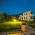 Kyparissia Blue Boutique Hotel in Kyparissía at dusk, with lawn, lit pathway, and white guest buildings