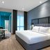 Ibis Styles Sepang Klia guest room with queen bed, desk, wall-mounted TV and window seating area