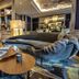 Hôtel des Beaux-Arts Toulouse lounge with curved sofa, swivel chair and layered coffee tables