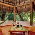 Riviera Maya Suites in Playa del Carmen, thatched palapa seating area with hammock and table setting