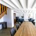 La Villa Bel Air in Flamanville dining room with long wooden table, blue sofas, and bright white interior
