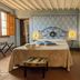 Antica Dimora Leones room in Palaia with wrought-iron bed, patterned wall, and open window