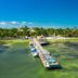 Portofino Beach Resort in San Pedro Town with a long pier over clear tropical water and boats