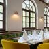 Leonardo Hotel & Residenz München dining room with set tables and mustard-yellow chairs in Munich
