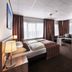 Sea You Hotel Noordwijk room with bed, sofa seating and attached bathroom in Noordwijk
