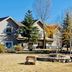 La Quinta Inn by Wyndham Steamboat Springs exterior with trees, landscaped fire pit area, and sign