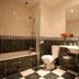 Hostellerie Les Hauts De Sainte Maure bathroom with bathtub, sink, toilet, and black-and-white tiled floor