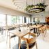 Grandhotel Brno in Brno dining room with wooden tables, chairs, large windows, and hanging greenery