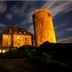 Night exterior of Hotel Burg Trendelburg in Trendelburg, showing a lit stone tower and castle building