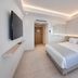 Mediterranean Hotel Rhodes guest room with king bed, wall-mounted TV, and modern minimalist design
