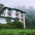 Ashley Resort in Nuwara Eliya beside misty forested hills and a narrow waterfall
