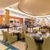 Pestana Porto Santo dining area with round tables, green chairs, and a bright buffet-style layout in Porto Santo