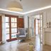 Son Sant Jordi, Pollença: bright guest room with lounge chair, French doors and adjoining bathroom.