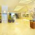 New Royal Hotel Shimanto lobby with bright yellow flooring, reception desk, staircase and floral arrangement
