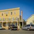 Mendocino Hotel and Garden Suites in Mendocino, yellow historic hotel with balcony and parked cars
