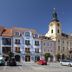 Hotel City Pisek in Písek with historic square, ornate towers, and parked cars under a blue sky