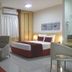 Bourbon Vitoria Residence Hotel room in Vitória with bed, armchair, desk and curtains