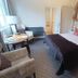 Chateau De Montreuil guest room in Montreuil with bed, seating area, and stone accent wall