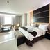 Grand Daira Hotel Palembang guest room with king bed, seating area, and large window in Palembang