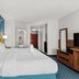 Comfort Inn & Suites Berea guest room with two beds, blue accent wall, TV, and hallway