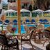 Esmeralda Hotel in Kremastí: outdoor poolside terrace with café tables, chairs, umbrellas and lounge chairs
