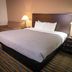 Quality Inn Noblesville-Indianapolis guest room with king bed, lamps, sofa, and patterned carpet
