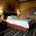 Hampton Inn & Suites Scottsburg guest room with queen bed, bedside lamps and striped carpet in Scottsburg