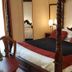 Hostellerie Les Hauts De Sainte Maure bedroom with four-poster bed and red-and-black bedding in Sainte-Maure-de-Touraine