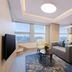 Luxemon Hotel (Pudong Shanghai) suite with city view, sofa, dining table and wall-mounted TV in Shanghai