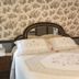Lost Bayou Guesthouse in Galveston bedroom with ornate bed, floral wallpaper and vintage decor