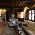 Casa de Aldea La Pumariega in Oviedo: rustic lounge with sofas, dining table, stone walls and wood beams