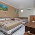 Hotel Mataram Malioboro Yogyakarta room with two beds, desk, wall art and air conditioner