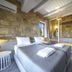 Asion Lithos in Kato Asites: stone-walled bedroom with twin beds, wood ceiling and mountain view