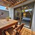Leopard Corner Lodge in Saint Lucia terrace with wooden table, chairs and sliding doors to bedroom