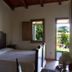 Domo Minnannu Miriu bedroom in Loiri Porto San Paolo with wooden bed and garden view through open door