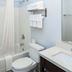 Luxbury Inn & Suites Maryville bathroom with tub-shower combo, toilet, sink, and towel rack