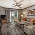 Club Wyndham Nashville living room with sofa, TV, patterned chairs and balcony doors