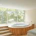 Hotel San Pedro del Fuerte in Medellín: guest room with a round soaking tub by large windows and a bed