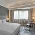 Vibe Hotel Singapore Orchard guest room with king bed, desk, chair and large window in Singapore