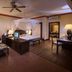 Diamonds Malindi room with canopy bed, desk, seating area and ceiling fan in Malindi