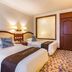 Guoyi Hotel Beijing guest room with two twin beds, bedside lamps, and patterned carpet