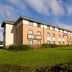 Purple Roomz Preston South (Cuerden Way) hotel exterior in Preston with green lawn and blue sky