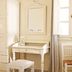 Meli Meli in Thera room with vanity desk, stool, chair, and bright window beside curtains