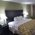 Baymont Inn & Suites Lake City guest room with king bed, bedside lamps and patterned bedspread